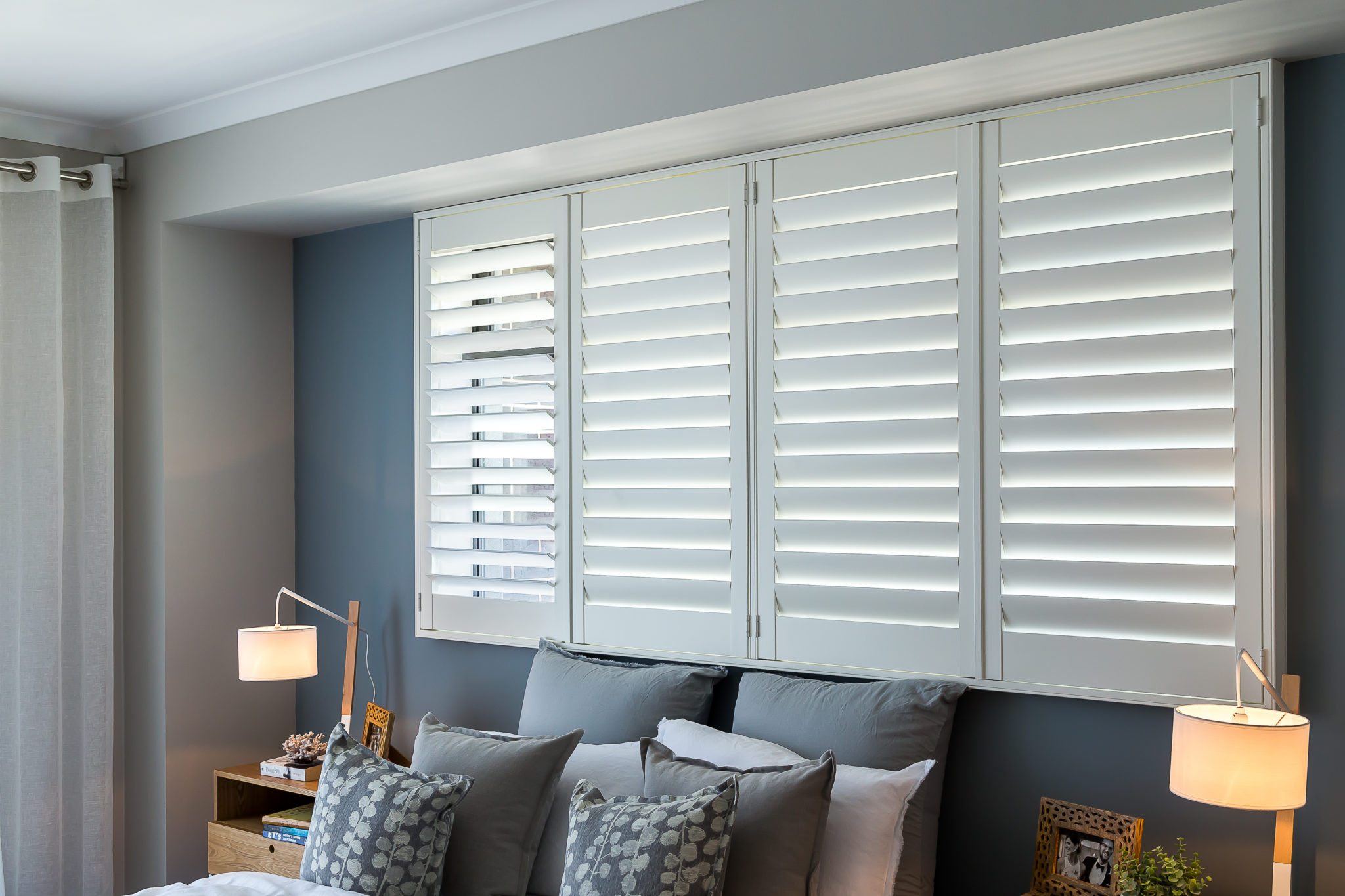 Elegant bedroom with custom plantation shutters in Houston – Premium window treatments for privacy, light control, and energy efficiency.