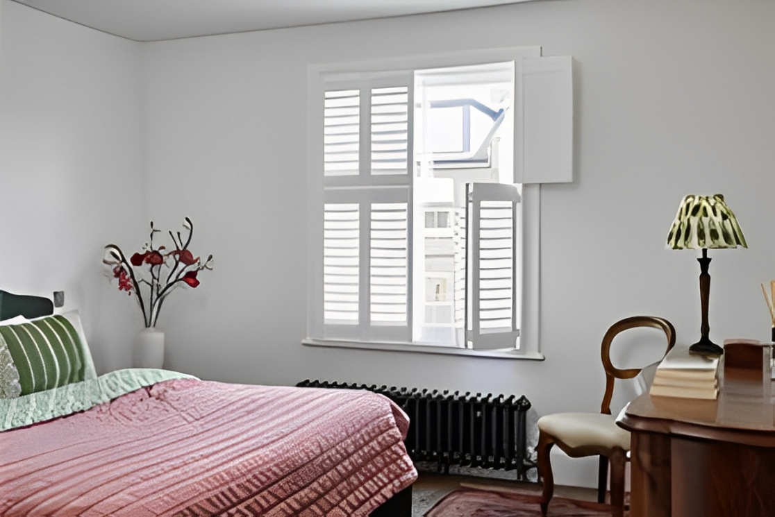 Tier-on-tier plantation shutters in a cozy Houston bedroom – Adjustable window treatments for privacy and natural light control.